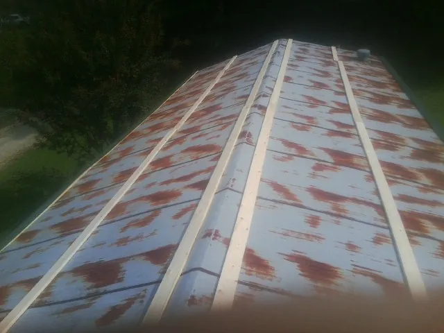 Rusted metal roof panels with new wood purlins before replacement — Storm Damage Roof Repair in Remlap by Roofing Brothers